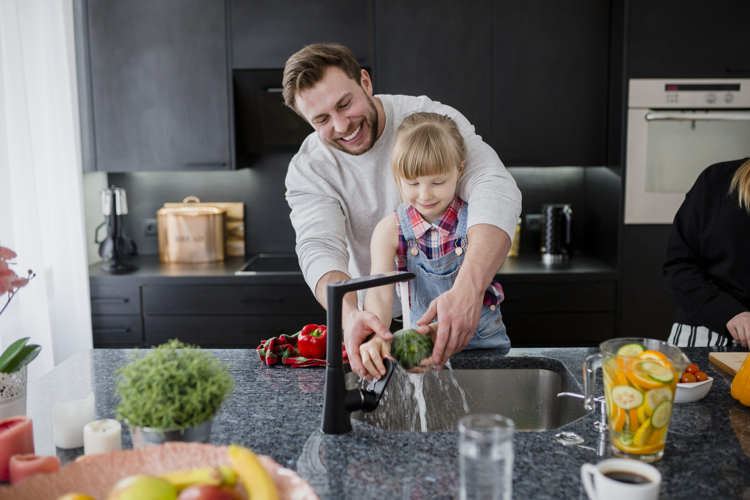 cheerful-father-daughter-washing-vegetables